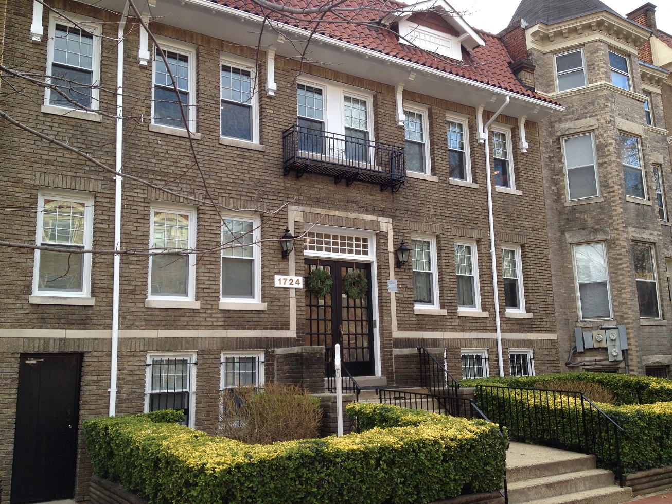 the front of a brick house with a brown door